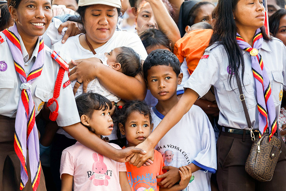 People gather outside the Irmas Alma School awaiting the arrival of Pope Francis in Dili, Timor-Leste, Sept. 10. (CNS/Lola Gomez)