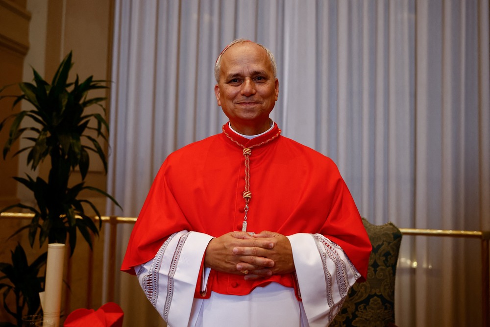 Prevost in red choir dress poses with folded hands.