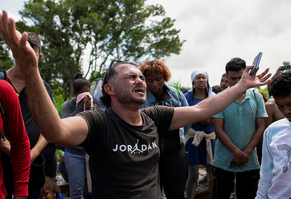 A migrant prays Aug. 22 in Sayula de Aleman, Mexico, along with others during a pause on their journey toward the U.S. border. (OSV News/Reuters/Angel Hernandez)