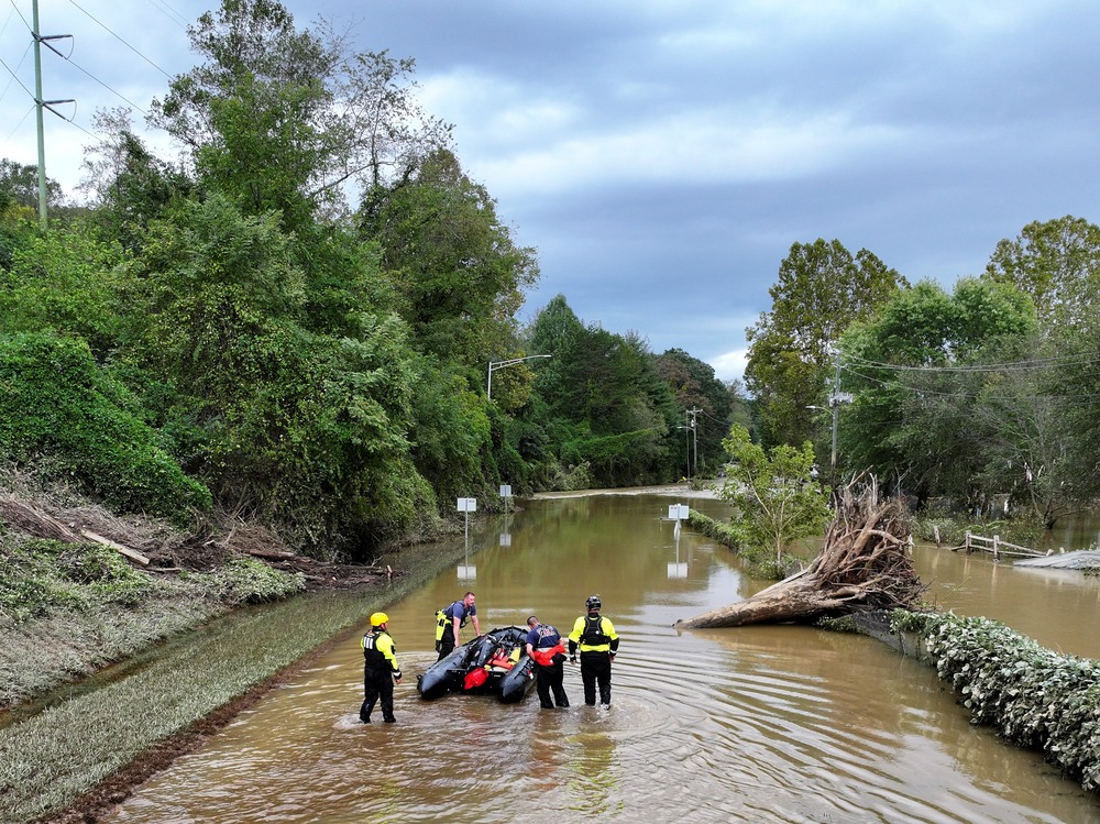 Group stands in middle of flooded area.