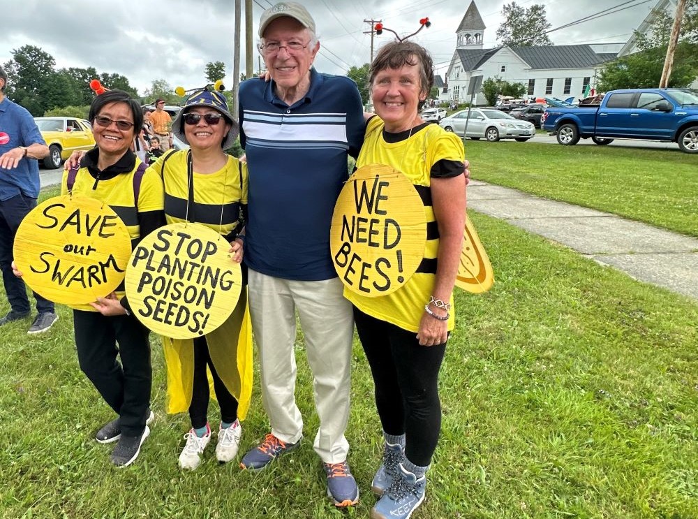 Sisters of the Earth community members pose with U.S. Sen. Bernie Sanders of Vermont at a 2024 Fourth of July parade in Greensboro, Vermont. 