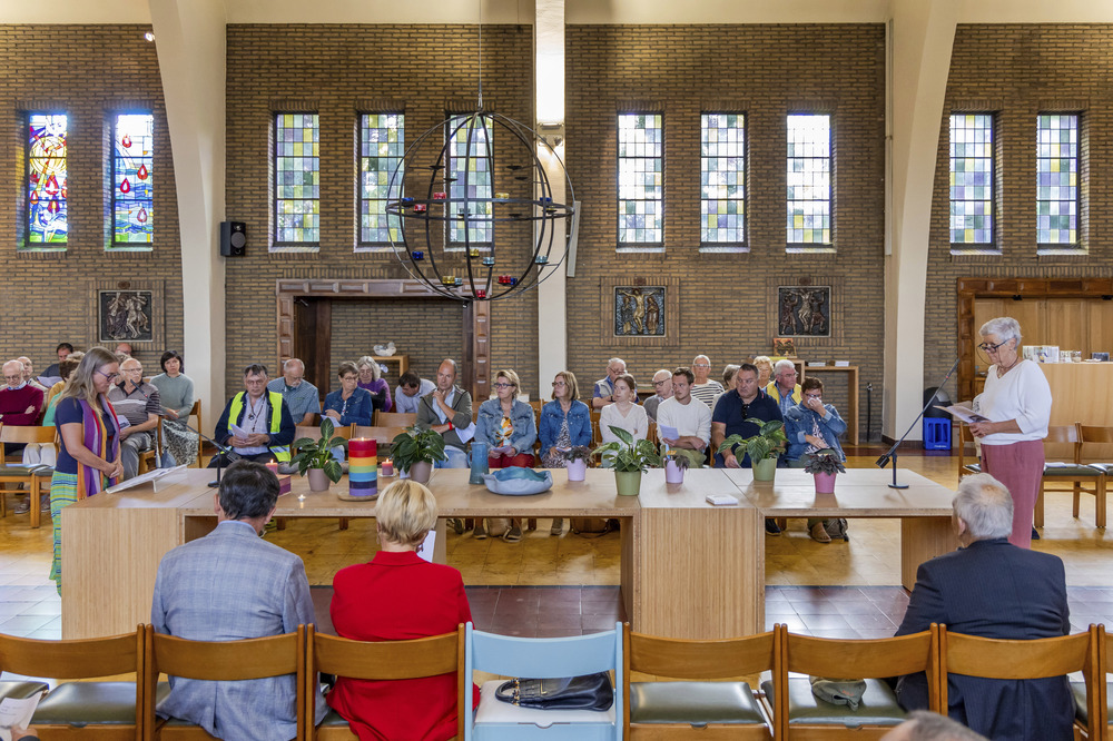 The two women stand at opposite ends of a long table, leading service.