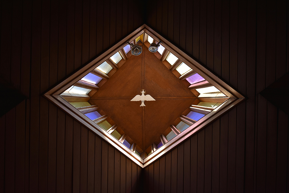 A dove on the ceiling surrounded by stained glass (Unsplash/Josh Eckstein)