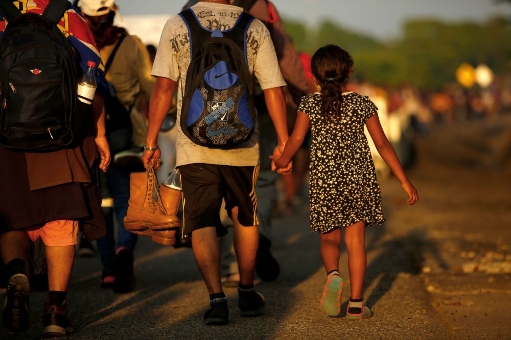 Jose Francisco from Honduras leads his 8-year-old daughter, Zuabelin, by the hand Nov. 22, 2021, as they take part in a caravan near Villa Mapastepec, Mexico, and head to the U.S. border. 