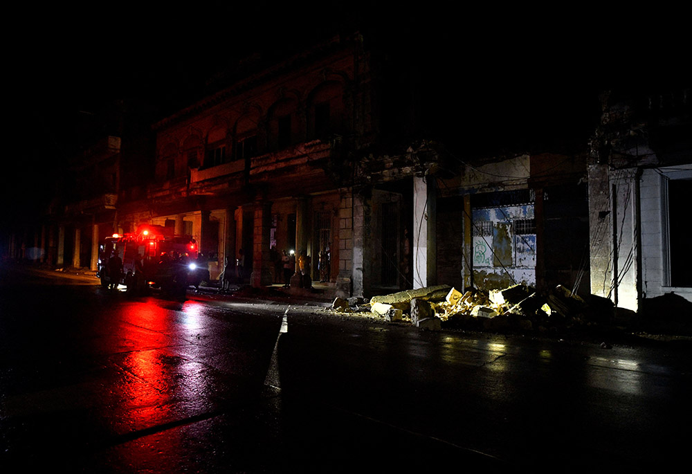 Firefighters check debris from a house during a blackout after Hurricane Rafael knocked out the country's electrical grid, Nov. 7 in Havana, Cuba. (OSV News photo/Reuters/Norlys Perez)