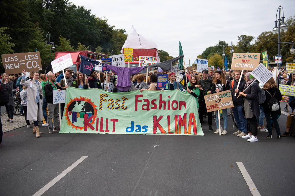 People carry signs against fast fashion during a Fridays For Future climate protest in Berlin in September 2019. (Wikimedia Commons/Stefan Müller)