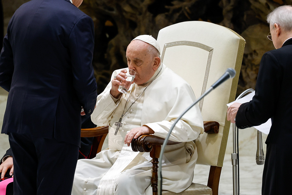 Pope Francis drinks water from a glass during his weekly general audience in the Paul VI Audience Hall at the Vatican Jan. 10, 2024. (CNS/Lola Gomez)