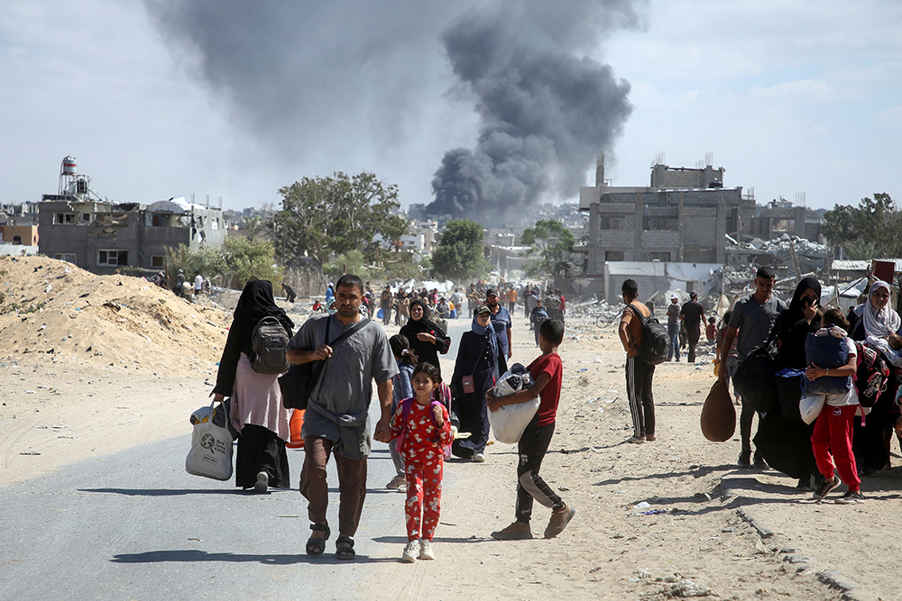 Smoke rises following an Israeli airstrike as displaced Palestinians make their way to flee areas in the eastern part of Khan Younis following an Israeli evacuation order, amid the ongoing Israel-Hamas war, in Khan Younis in the southern Gaza Strip Oct. 7, 2024. (OSV News/Reuters/Hatem Khaled)