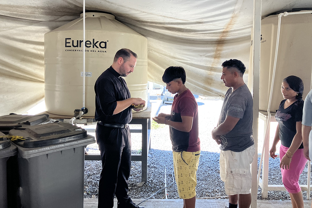 Jesuit scholastic Joseph Nolla distributes Communion during Mass celebrated Oct. 15, 2024, at the Senda de Vida migrant shelter in Reynosa, Mexico. (OSV News/David Agren)