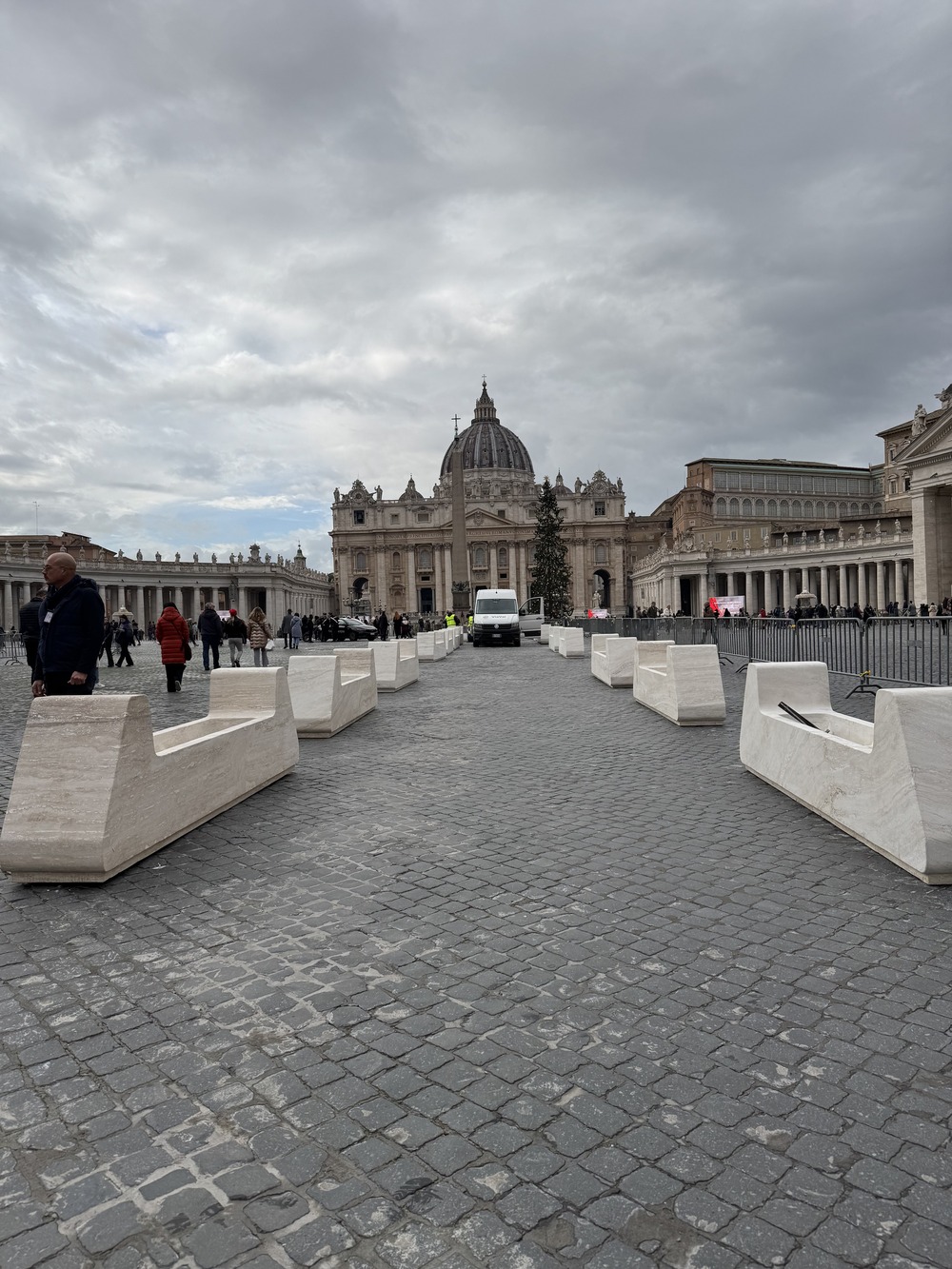 View of long path culminating in Basilica against gray sky.