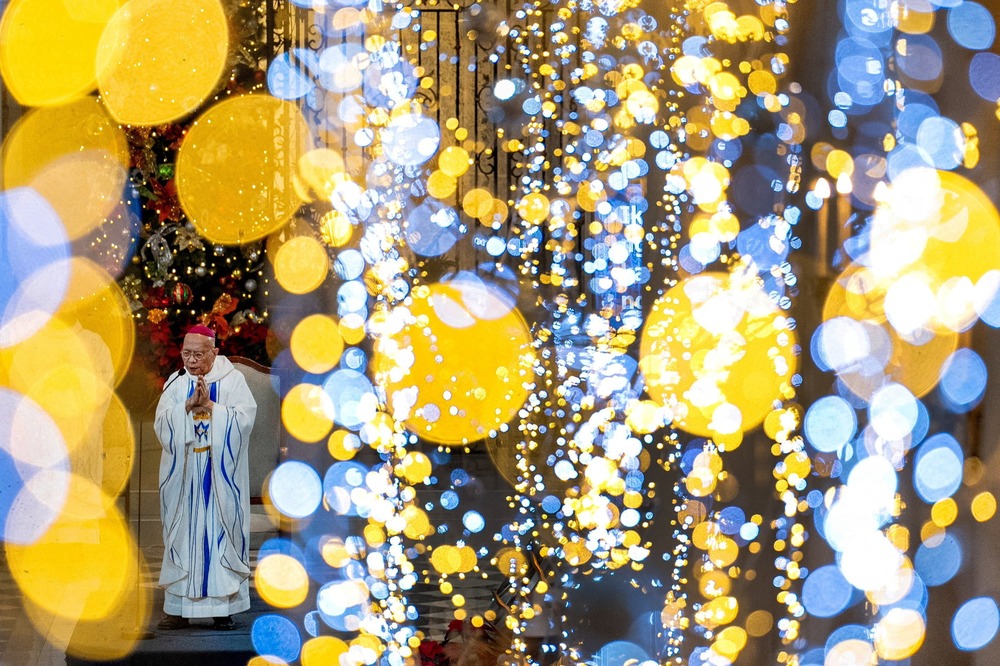 The bishop is seen in the lower left corner, majority of frame is covered by sparkling, indistinct lights.