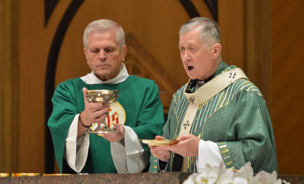 Chicago Cardinal Blase J. Cupich, right, celebrates Mass at Holy Name Cathedral in Chicago June 30, 2024. Cupich is calling for faithful to receive holy Communion standing -- the normative posture established by the U.S. Catholic bishops -- as part of a renewed awareness of the theology of the Communion procession, which symbolizes the unity of the body of Christ as it partakes of the central mystery of the Catholic faith. (OSV News photo/Simone Orendain)