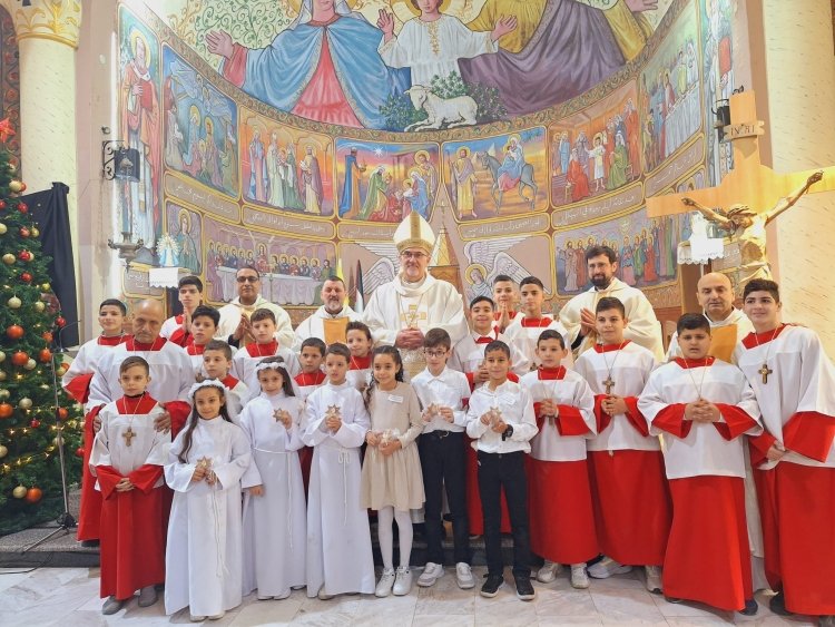 The cardinal vested in white, stands with many young peoples vested as acolytes, as well as the confirmands standing in middle.