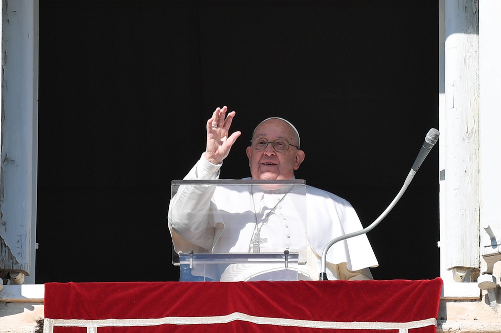 The pope waves from window. 