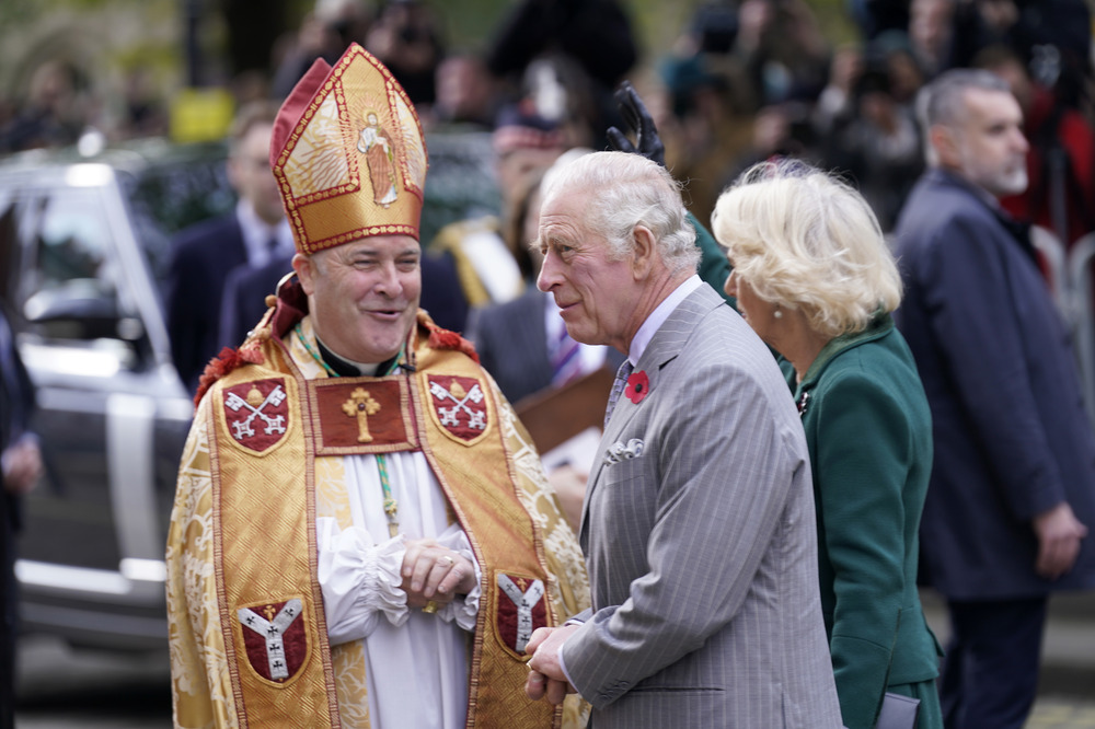 The prelate, vested, smiles at the King. 