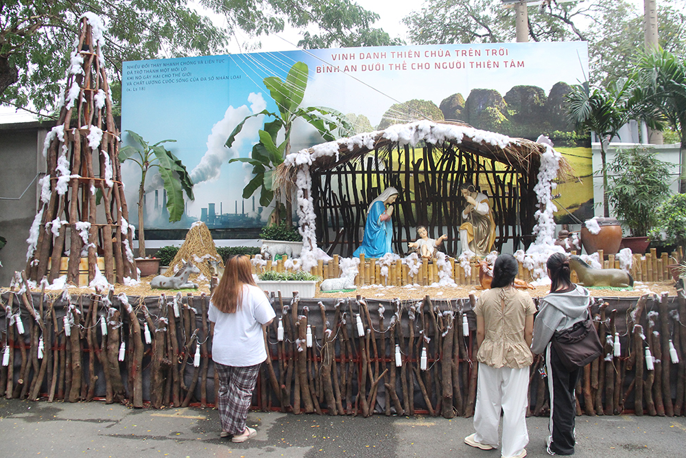 People visit a nativity made of hay, thatch, bamboo, pieces of wood, cotton, bonsais, and other used items on Dec. 19 in the compound of Dong Tien Church in Ho Chi Minh City. (Joachim Pham)