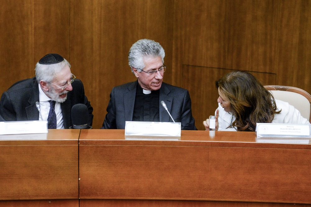 The rabbi on the left, the priest in the center, and the director on the right; the three sit on a panel, facing each other and talking.