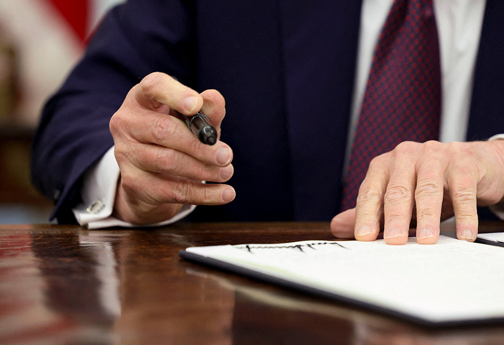 U.S. President Donald Trump signs an executive order in the Oval Office of the White House, Jan. 23 in Washington. (OSV News/Reuters/Kevin Lamarque)