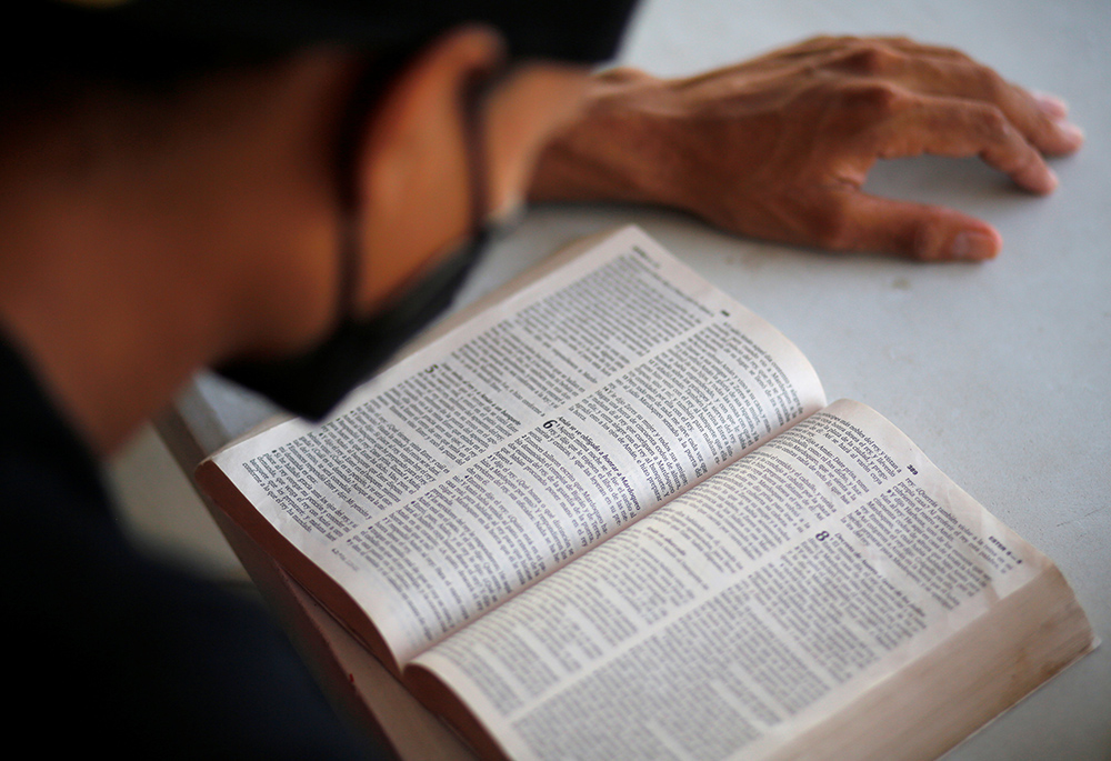 A Central American migrant who was deported by U.S. and Mexican officials reads the Bible at a shelter in El Ceibo, Guatemala, on Aug. 15, 2021. (CNS/Reuters/Luis Echeverria)