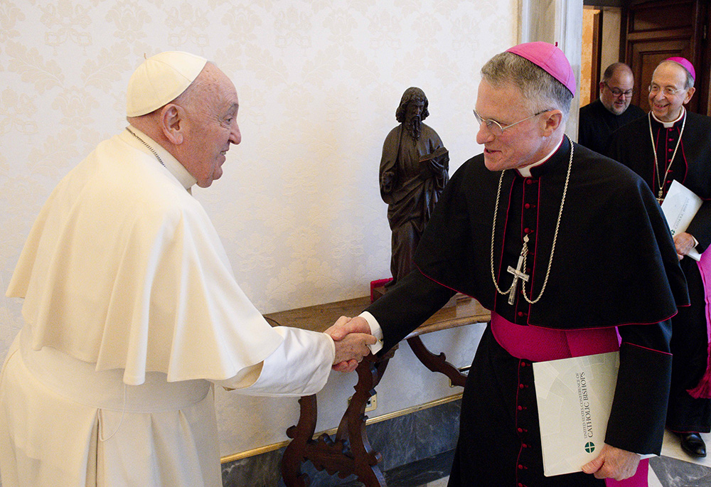 Pope Francis greets Archbishop Timothy Broglio, president of the U.S. Conference of Catholic Bishops and head of the U.S. Archdiocese for the Military Services, in the library of the Apostolic Palace at the Vatican on April 18, 2024. The pope usually meets with the conference's officers twice each year. (CNS/Vatican Media)