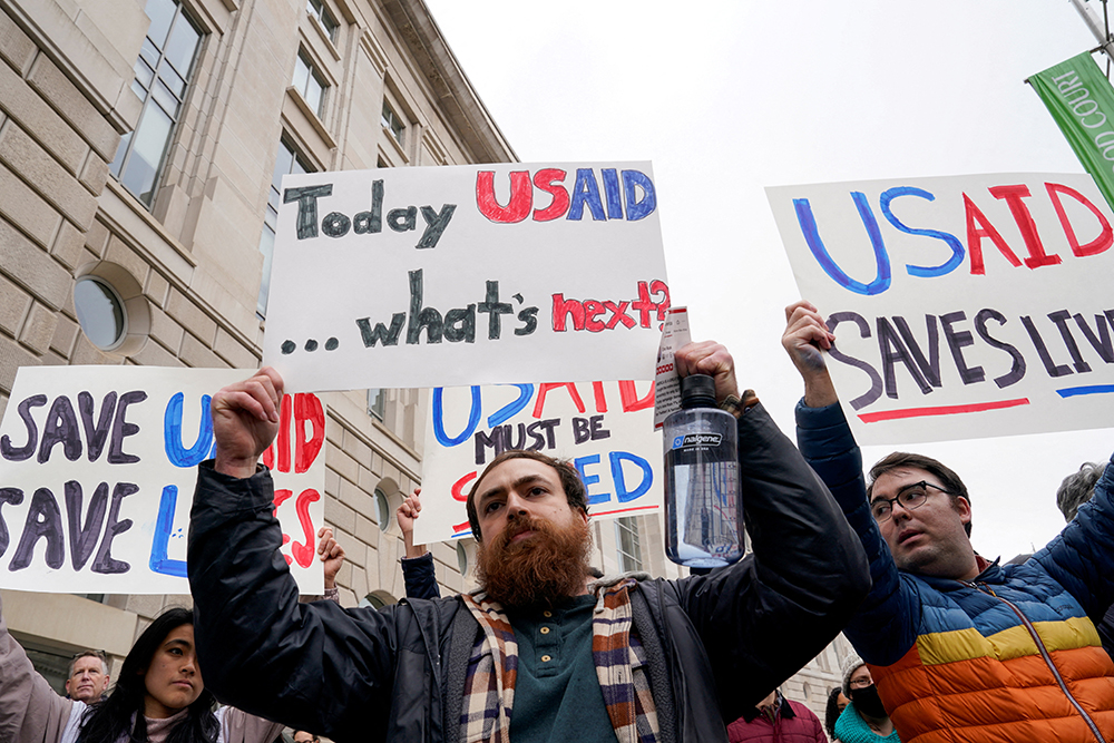 People hold placards outside the USAID building, after billionaire Elon Musk, who is heading U.S. President Donald Trump's drive to shrink the federal government, said work is underway to shut down the U.S. foreign aid agency USAID, in Washington, U.S., Feb. 3, 2025. (Reuters/Kent Nishimur)