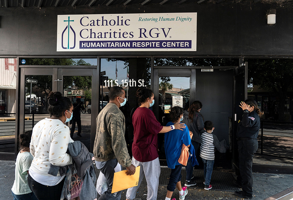 Migrants seeking asylum in the U.S. walk into a temporary humanitarian respite center run by Catholic Charities of the Rio Grande Valley, April 8, 2021, in McAllen, Texas. (CNS/Reuters/Go Nakamura)