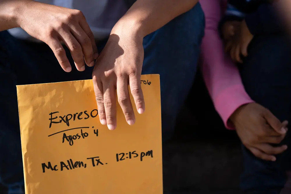 Only Ledezma's hands are shown, holding folder.