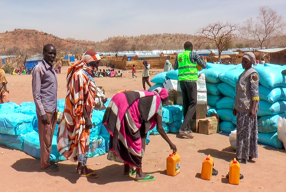 Sudanese refugees displaced by the conflict in Sudan gather to receive food staples from aid agencies at the Metche Camp in eastern Chad March 5, 2024. Jesuit Refugee Service is the United Nations' designated lead for education in Chad's 19 refugee camps. (AP/Jsarh Ngarndey Ulrish, File)