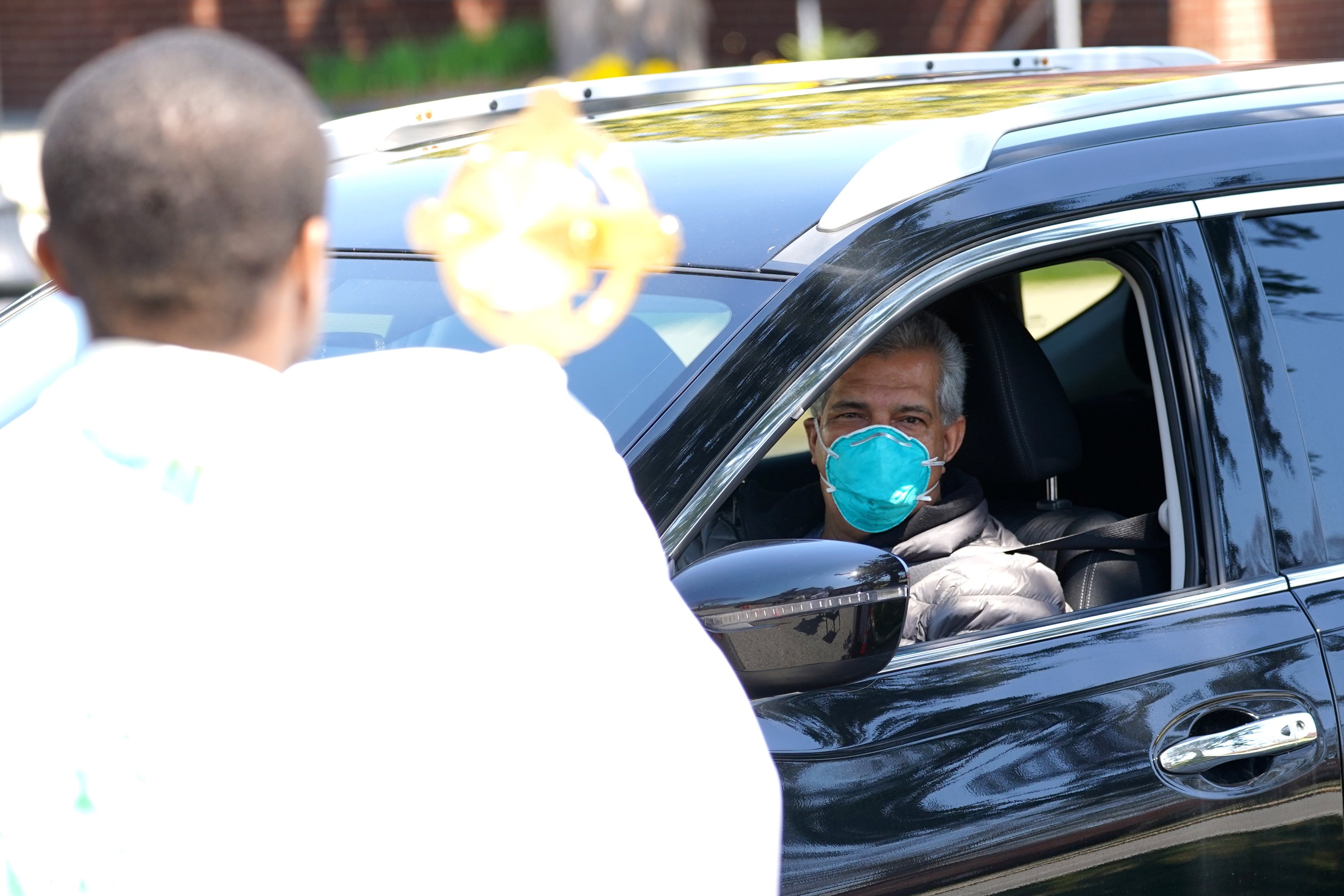 Motorist glances at a monstrance during a drive-thru blessing service.