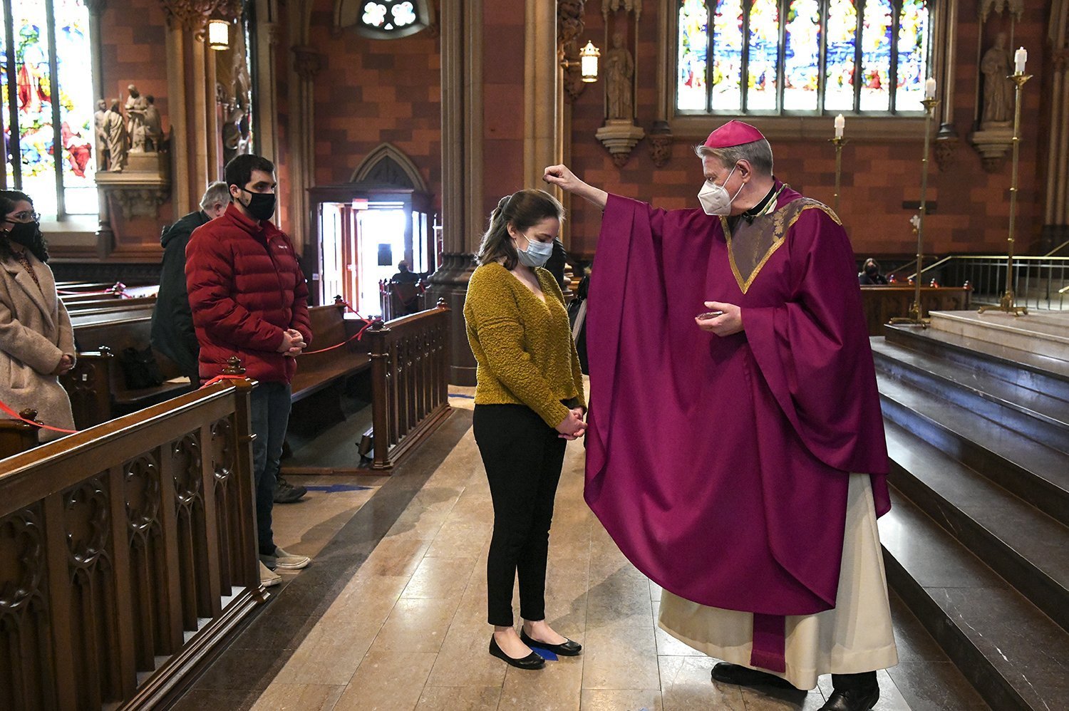 Bishop Edward B. Scharfenberger of Albany, N.Y., sprinkles ashes on parishioners.