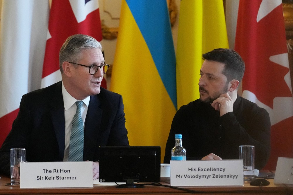 Starmer and Zelenskyy sit side by side on panel.