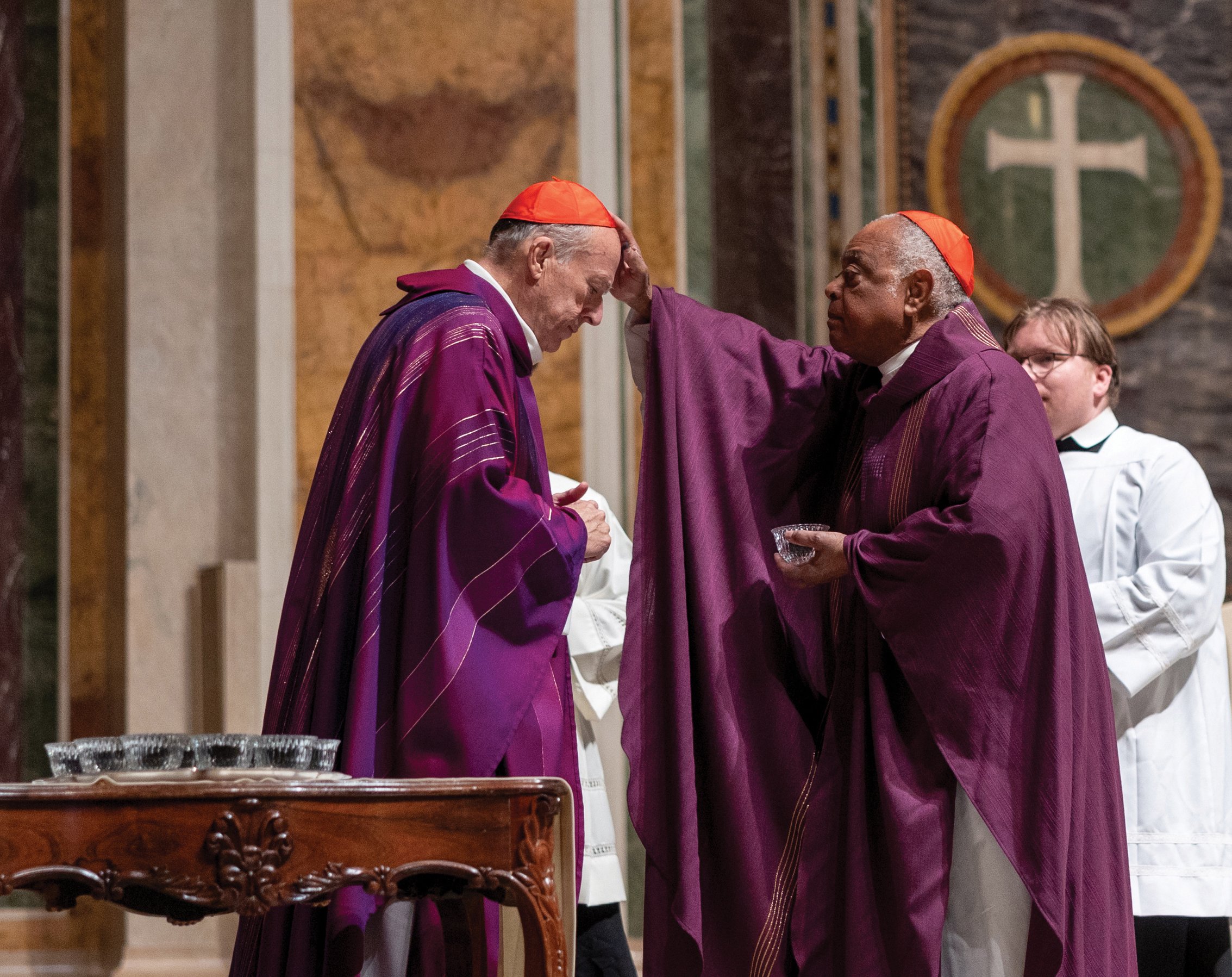 Cardinal Wilton D. Gregory, right, the retiring archbishop of Washington, dispenses ashes to Cardinal Robert W. McElroy, during Ash Wednesday Mass March 5, 2025, at the Cathedral of St. Matthew the Apostle in Washington. Cardinal McElroy will be installed March 11 as the eighth archbishop of Washington. (OSV News photo/Mihoko Owada, Catholic Standard)