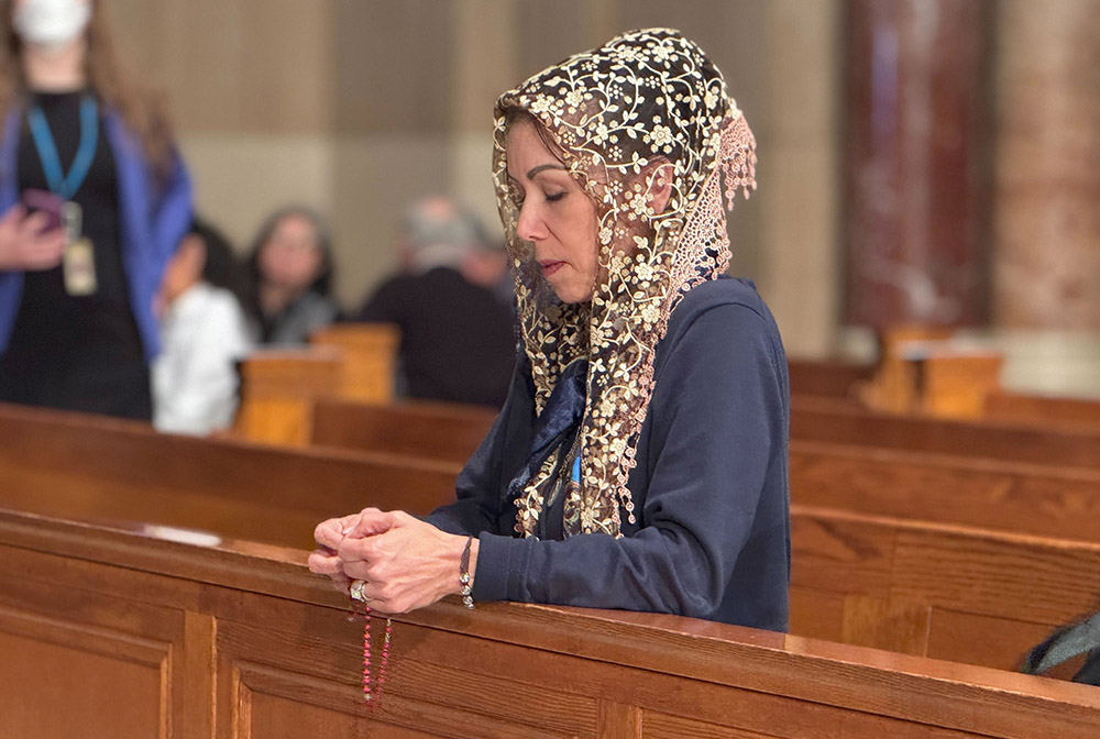 A woman prays before the installation Mass March 11 of Washington Cardinal Robert McElroy at the Basilica of the Shrine of the Immaculate Conception in Washington, D.C. (NCR photo/Rhina Guidos)