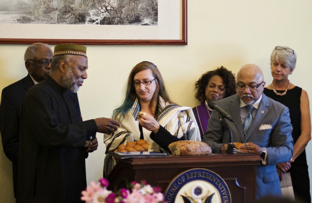 Imam Johari Abdul-Malik shares bread with Rabbi Alana Suskin at an interfaith prayer service in the Cannon House Office Building in Washington, D.C., May 8. (NETWORK Lobby for Catholic Social Justice/Mehreen Karim)