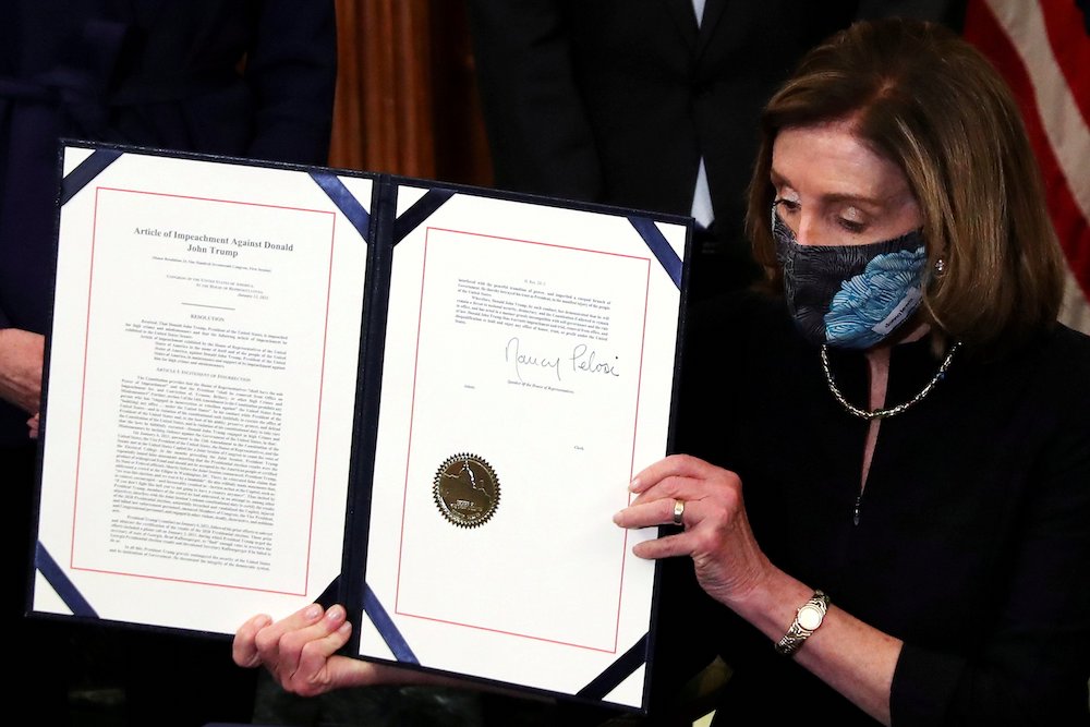 House Speaker Nancy Pelosi, D-Calif., shows the article of impeachment against President Donald Trump after signing it in an engrossment ceremony at the U.S. Capitol in Washington Jan. 13, 2021. (CNS/Reuters/Leah Millis)