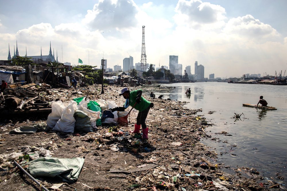 A volunteer member of River Warriors cleans up trash on the banks of the heavily polluted Pasig River in Manila, Philippines. Bishop Noel Pedregosa, new leader of the Malaybalay Diocese in southern Philippines, said he plans to emphasize environment-focus