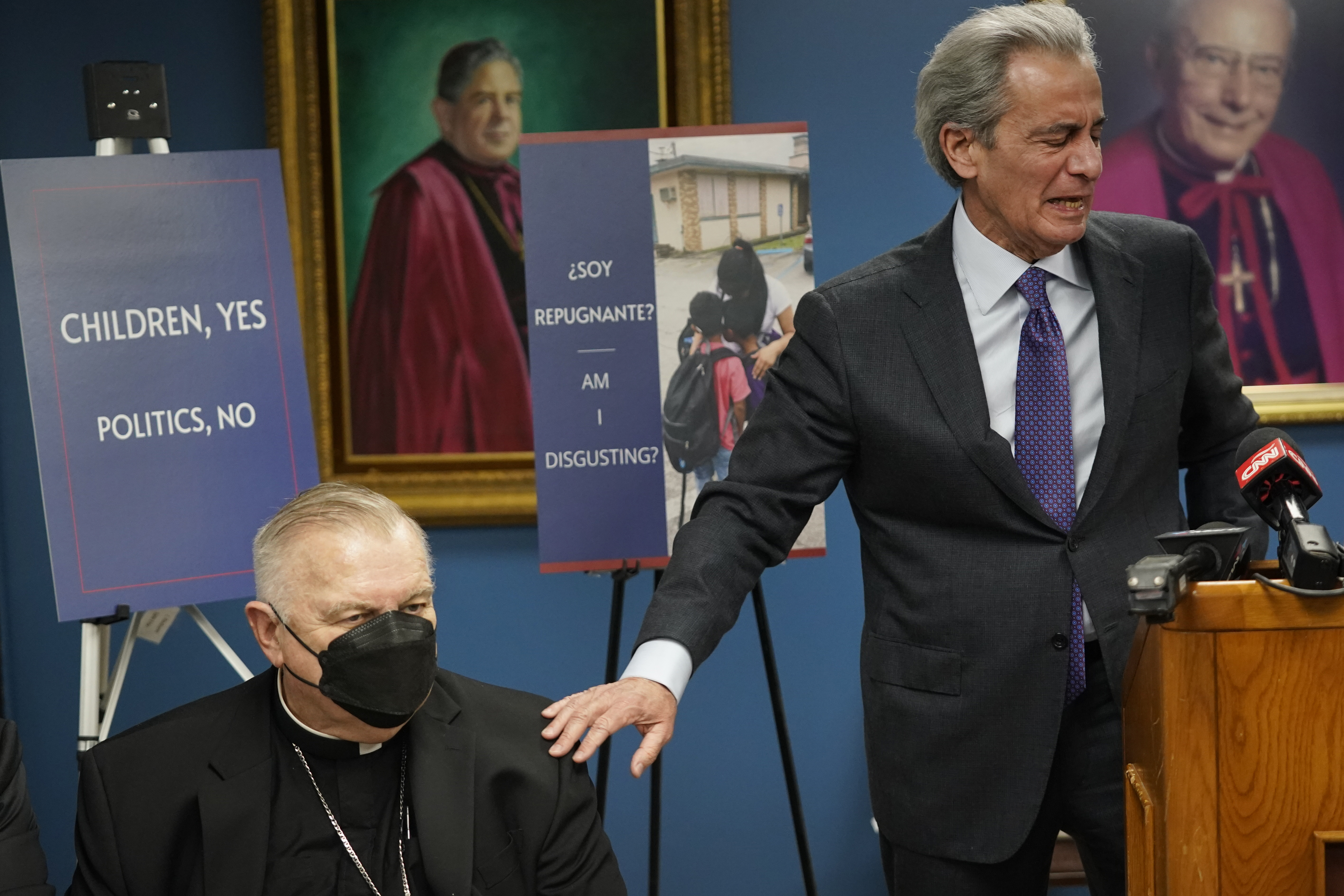 Tony Argiz, right, puts his hand on Archbishop of Miami Thomas Wenski 's shoulder as he speaks during a news conference, at the Archdiocese of Miami Pastoral Center in Miami Shores, Fla.,  Feb. 10, 2022, (AP Photo/Wilfredo Lee)