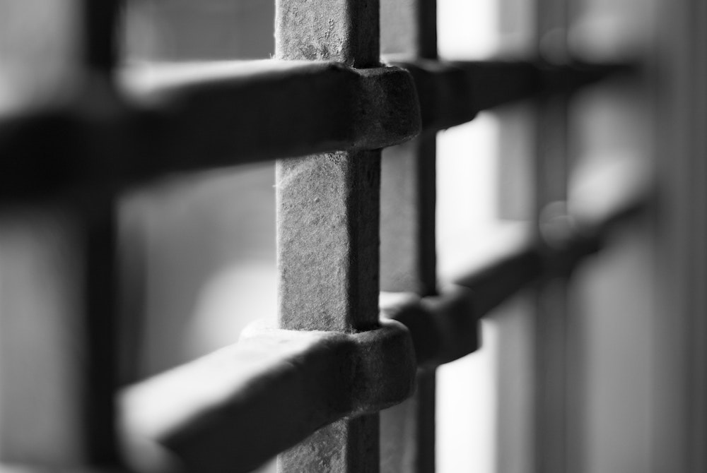 Prison bars illustration (Unsplash/Marco Chilese)