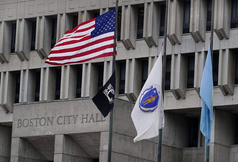 The American flag, the Commonwealth of Massachusetts flag, and the City of Boston flag, from left, fly outside Boston City Hall May 2. (AP/Charles Krupa)