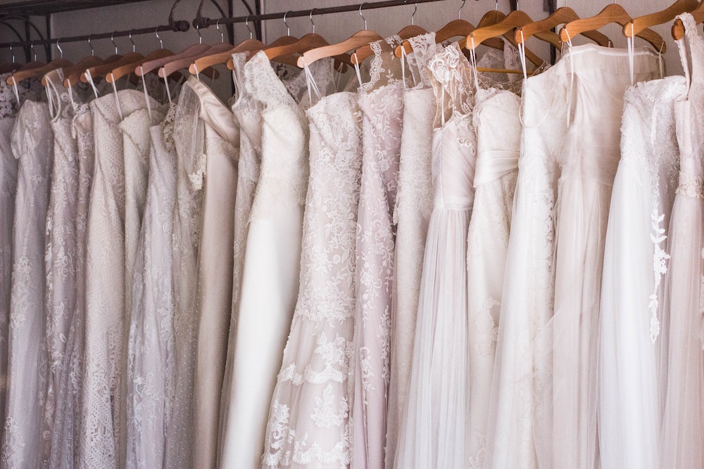 Wedding dresses hanging on a rack (Unsplash/Charisse Kenion)