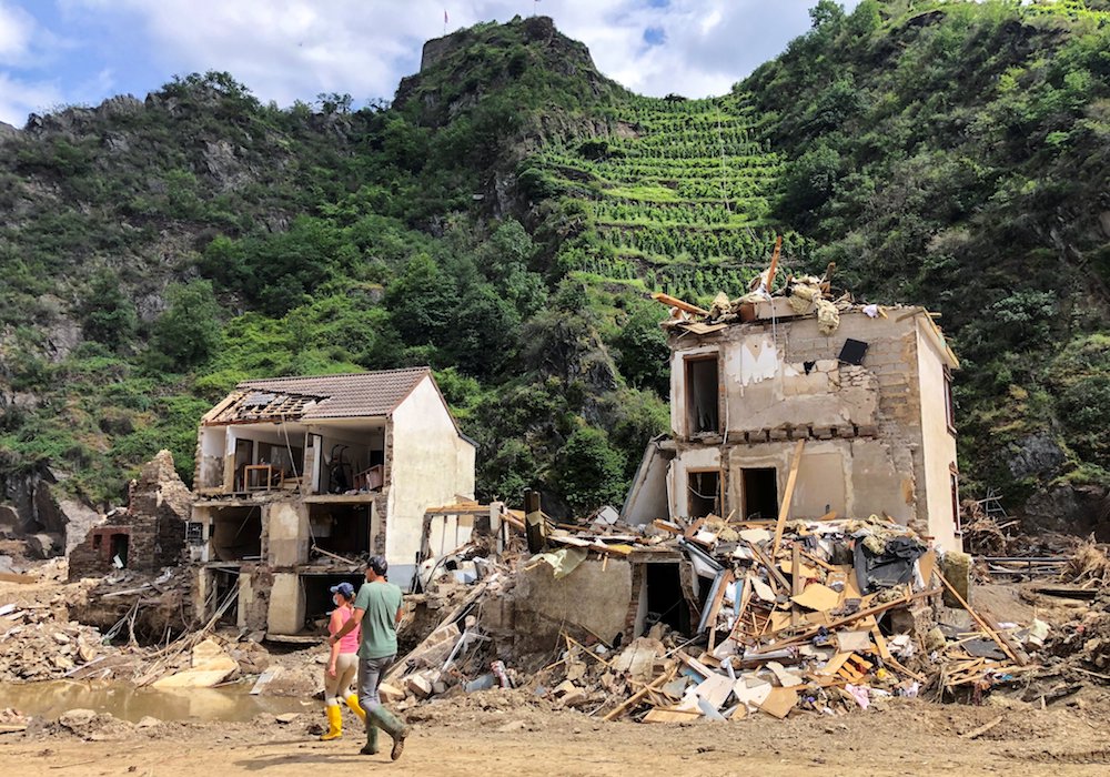 Residents walk past destroyed homes in Mayschoss, Germany, July 29, following historic flooding. At least 160 people have died in the flooding. Germany's churches plan to hold an ecumenical service in Aachen cathedral Aug. 28 to commemorate the victims. (