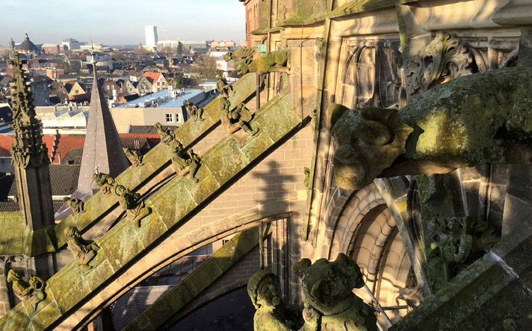 Gargoyles look down on figures on the flying buttresses of St. John's Cathedral in Den Bosch, Netherlands. (Menachem Wecker)