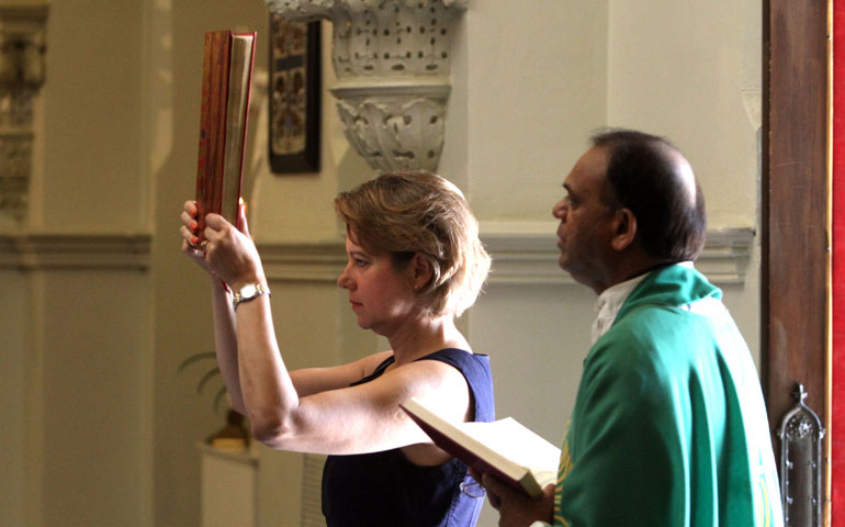 Lynne Mapes-Riordan takes part in a Sunday Mass procession at St. Nicholas Church in Evanston, Ill., July 15. At right is visiting priest Fr. Casmir Damor. (LANDOV/MCT/Chicago Tribune/Chuck Berman)