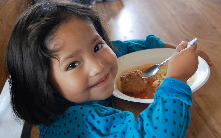 A girl in Mexico eats a meal provided by the Helping Hands Association and Caritas, the Catholic relief and development organization. Caritas Internationalis launches its campaign against hunger Tuesday with a worldwide prayer. Nearly 1 billion people -- about one in every eight -- experienced chronic hunger or undernourishment during 2010-2012, according to Caritas. (CNS photo/courtesy of Caritas Internationalis)