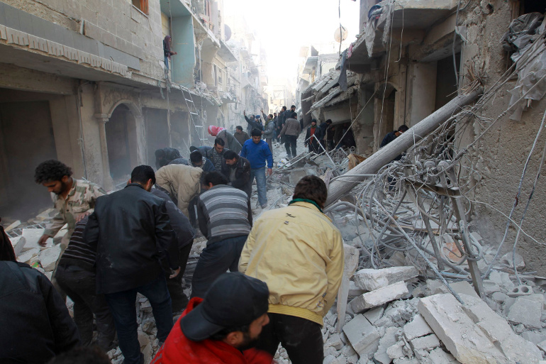 Residents search for survivors after what activists said were air strikes by forces loyal to Syrian President Bashar Assad in Aleppo Dec. 28. Former British Prime Minister Tony Blair and former Egyptian Vice President Mohamed ElBaradei are among the key political experts invited by the Vatican for a one-day meeting aimed at promoting a cease-fire in Syria, the protection of Christians there and a transitional and unified government. (CNS/Reuters/Jalal Alhalabi)