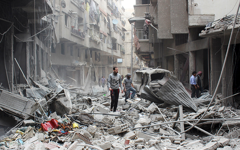 Civilians inspect a damaged site after what activists said were airstrikes by forces loyal to Syria's President Bashar Assad in the Damascus suburb of Ain Tarma May 14, 2015. (CNS/Reuters)