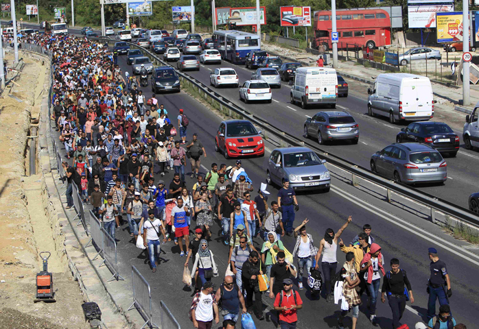 Migrants walk along a highway in Bicske, Hungary, near the border with Austria Sept. 4. (CNS/Bernadett Szabo, Reuters)