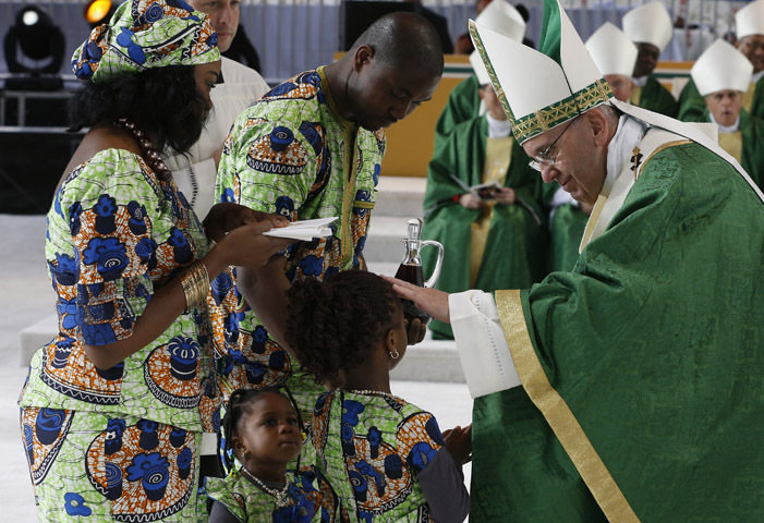 Pope Francis blesses a girl as her family presents offertory gifts during the closing Mass of the World Meeting of Families along Benjamin Franklin Parkway in Philadelphia Sept. 27. (CNS/Paul Haring)