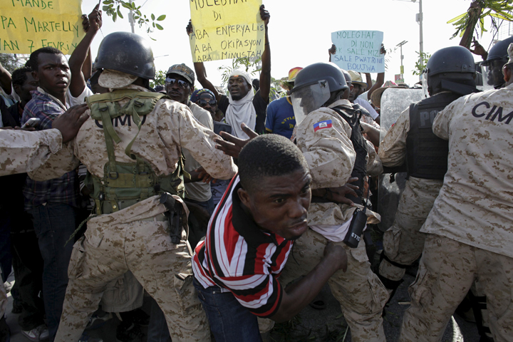 A man crosses a police cordon during a protest against the government and the electoral process Jan. 29 in Port-au-Prince, Haiti. (CNS/Andres Martinez Casares, Reuters) 