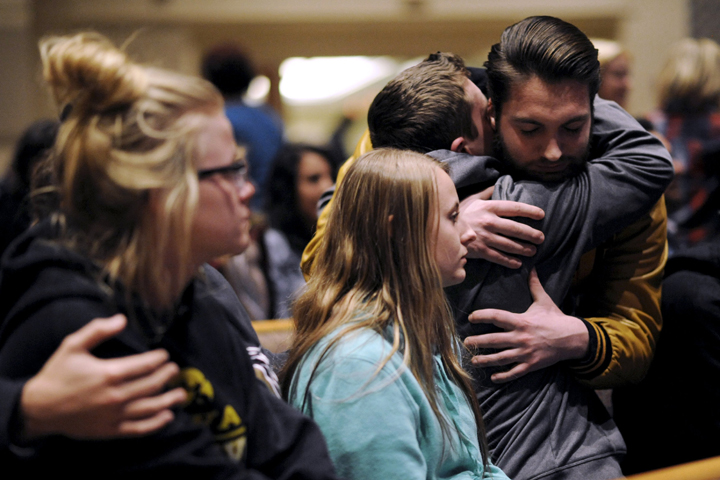 People hug at a vigil after six people were killed in a random shooting in Kalamazoo, Mich., Feb. 21. (CNS/Mark Kauzlarich, Reuters)